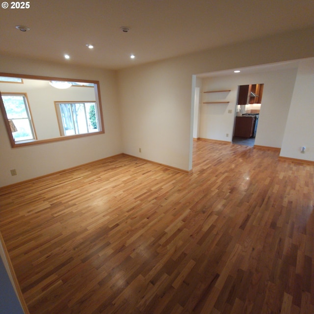 empty room featuring wood finished floors, recessed lighting, and baseboards