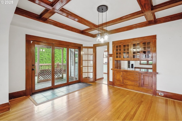 doorway to outside featuring beam ceiling, light wood-type flooring, coffered ceiling, and an inviting chandelier