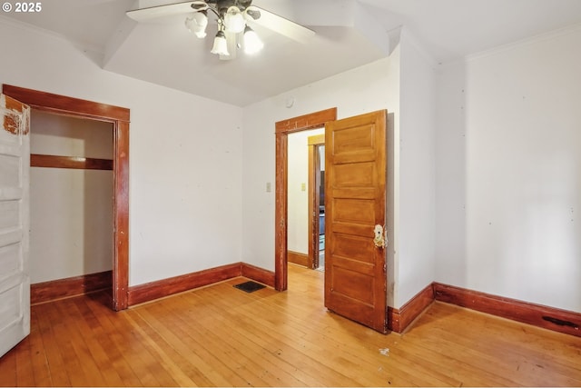 unfurnished bedroom with ceiling fan, a closet, ornamental molding, and hardwood / wood-style flooring