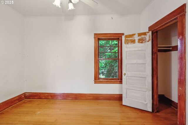 interior space with a closet, hardwood / wood-style flooring, ceiling fan, and ornamental molding