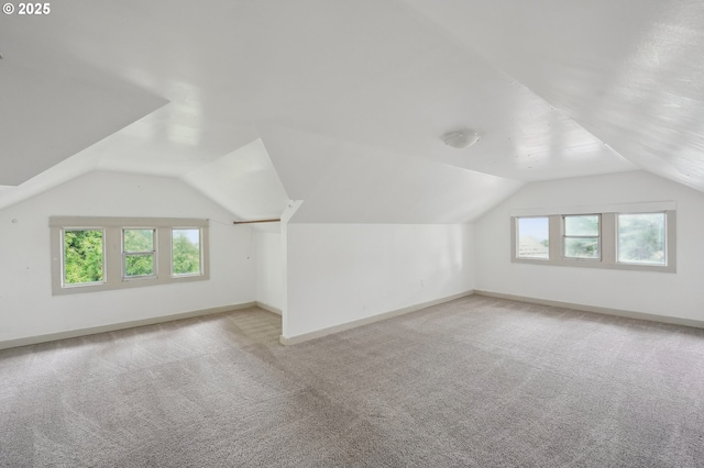 bonus room with light carpet and vaulted ceiling