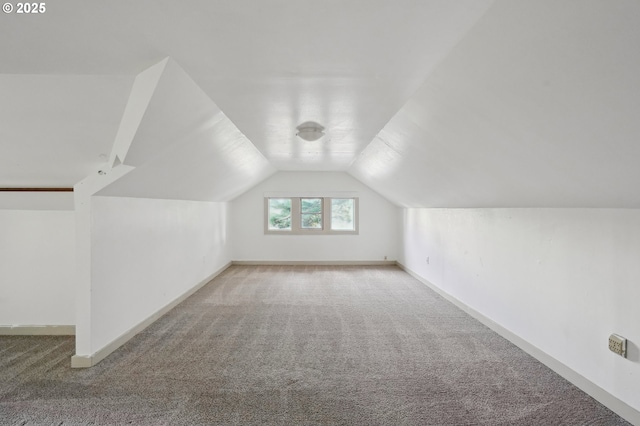 additional living space featuring carpet floors and vaulted ceiling