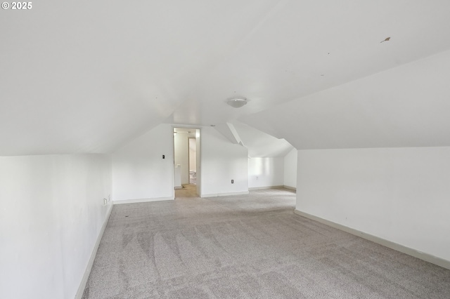 additional living space featuring light carpet and lofted ceiling