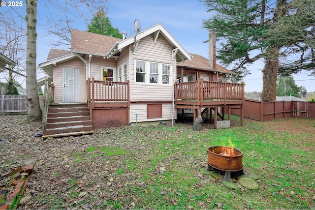 back of property featuring a lawn and a deck