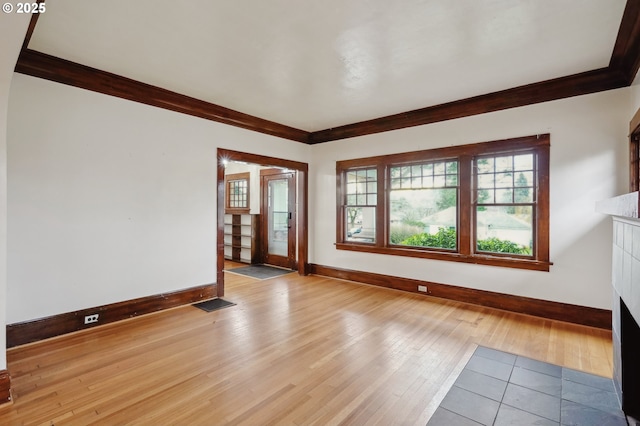 empty room with light hardwood / wood-style floors and ornamental molding