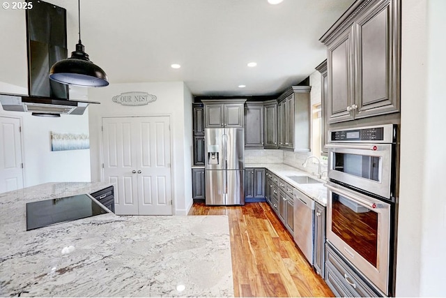 16295 SE Slate St, Damascus, OR 97089 - kitchen featuring appliances with stainless steel finishes, gray cabinets, light wood-style flooring, light stone countertops, and recessed lighting