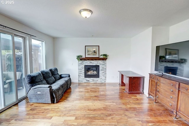 16295 SE Slate St, Damascus, OR 97089 - living room with a stone fireplace, light wood-style floors, and baseboards