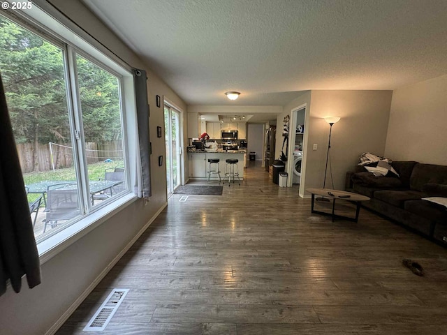 6307 NE Wilding Rd, Vancouver, WA 98686 - living room with a textured ceiling, dark wood finished floors, and washer / dryer