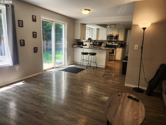 6307 NE Wilding Rd, Vancouver, WA 98686 - kitchen with appliances with stainless steel finishes, white cabinetry, a peninsula, and dark wood finished floors