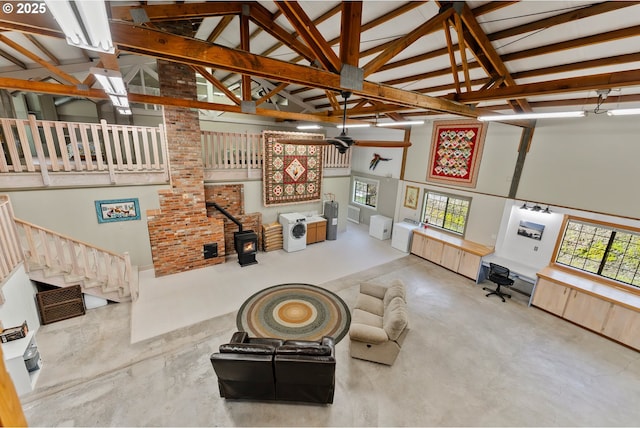 living room featuring high vaulted ceiling, a wood stove, concrete floors, and ceiling fan