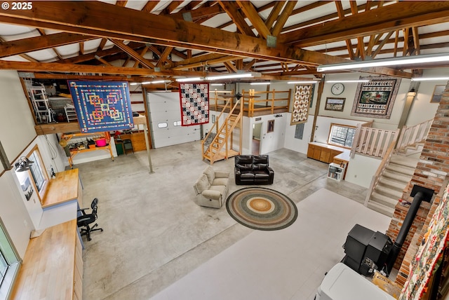 living area featuring lofted ceiling, concrete floors, and stairs