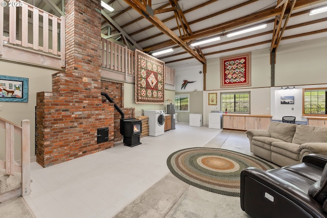 living room featuring high vaulted ceiling, a wood stove, beamed ceiling, and washer / dryer