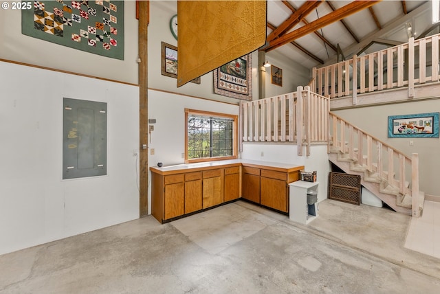 kitchen with concrete flooring, high vaulted ceiling, light countertops, electric panel, and brown cabinetry