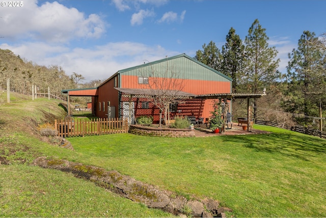 back of property with an outbuilding, fence, and a lawn