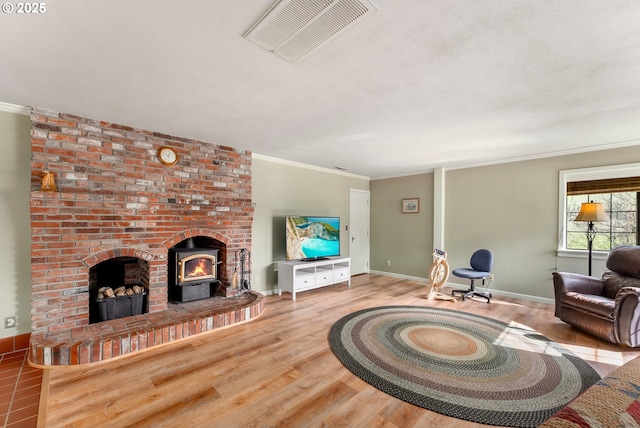 living area featuring ornamental molding, visible vents, baseboards, and wood finished floors