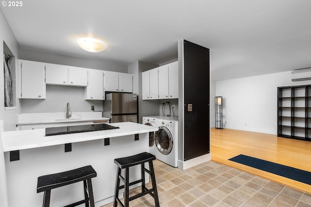100 NE 78th Ave, Portland, OR 97213 - washroom with washer / dryer, a wall unit AC, and baseboards