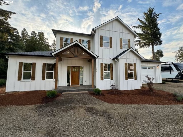 modern inspired farmhouse with an attached garage, board and batten siding, and driveway