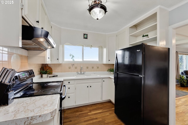 kitchen with light countertops, white cabinetry, a sink, under cabinet range hood, and black appliances