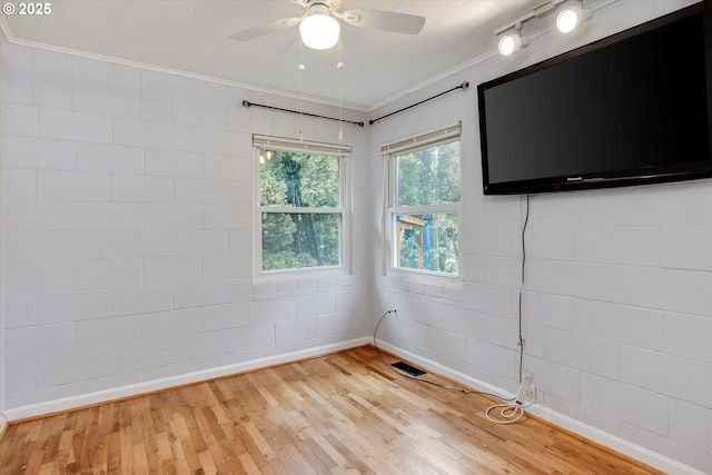 unfurnished room with ceiling fan, baseboards, crown molding, and wood finished floors