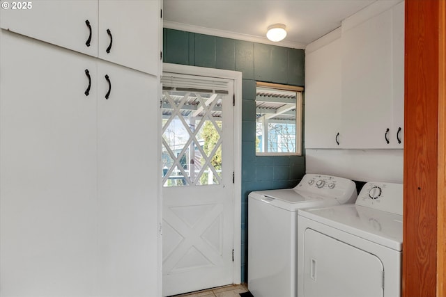 laundry area featuring cabinet space, crown molding, and washing machine and clothes dryer