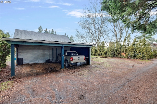 garage featuring an attached carport and driveway