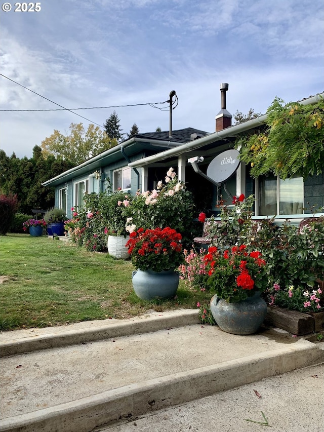 single story home featuring a chimney and a front lawn