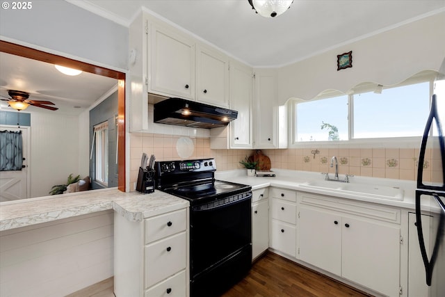 kitchen featuring under cabinet range hood, a sink, white cabinets, light countertops, and black appliances