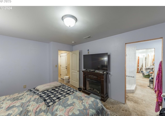 bedroom with a glass covered fireplace and visible vents