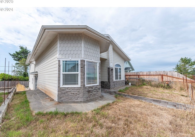 exterior space with stone siding and fence