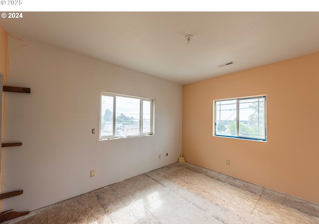 unfurnished room featuring visible vents and a healthy amount of sunlight