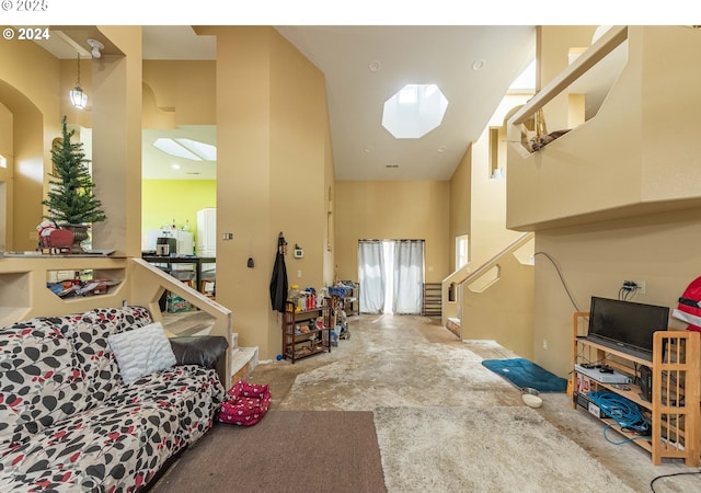 living area with stairs, a skylight, and a towering ceiling