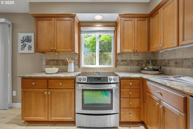 17221 SW Oakenshield Ct, Portland, OR 97224 - kitchen with electric stove, backsplash, light stone countertops, and brown cabinets