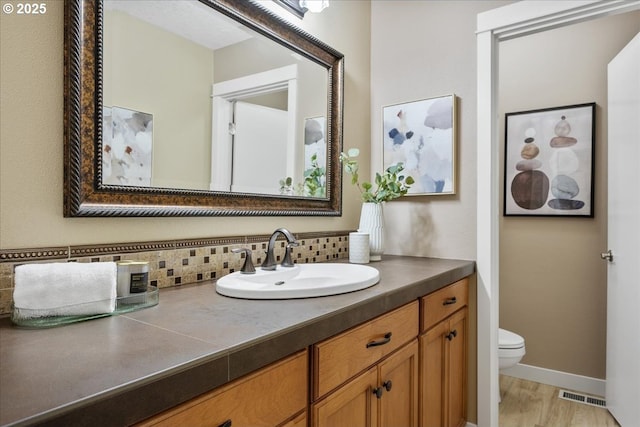 17221 SW Oakenshield Ct, Portland, OR 97224 - bathroom with tasteful backsplash, vanity, and wood finished floors