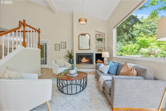 17221 SW Oakenshield Ct, Portland, OR 97224 - living area featuring wood finished floors, a fireplace, stairway, built in shelves, and high vaulted ceiling