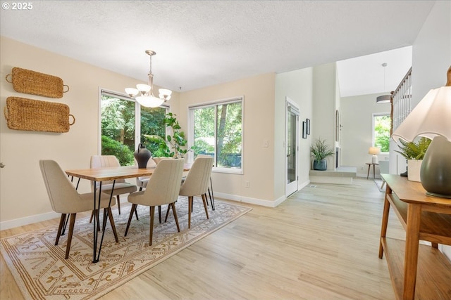 17221 SW Oakenshield Ct, Portland, OR 97224 - dining room featuring light wood-style floors, a chandelier, and a textured ceiling