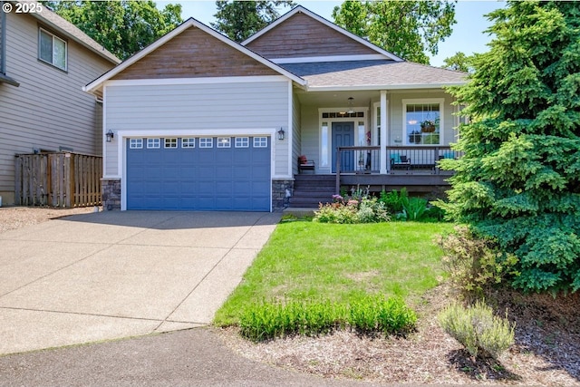 view of front of home featuring a garage, a front yard, and a porch