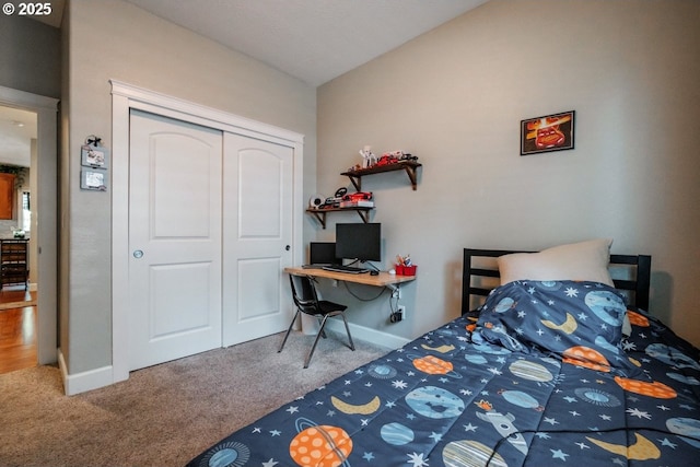 carpeted bedroom with lofted ceiling and a closet