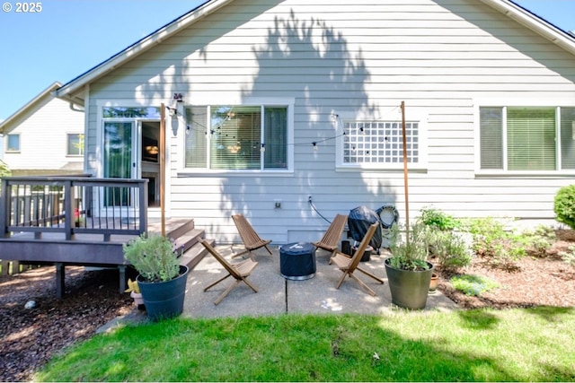 back of house with a yard, a deck, and a fire pit