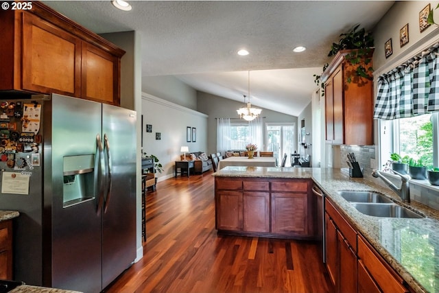 kitchen featuring sink, stainless steel appliances, a wealth of natural light, vaulted ceiling, and kitchen peninsula