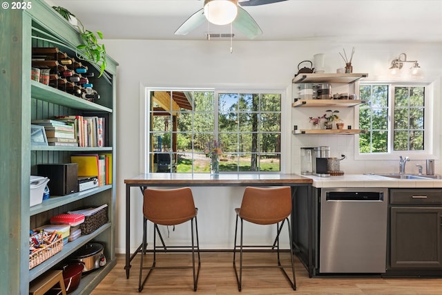 14955 Profitt Loop, Baker City, OR 97814 - kitchen with stainless steel dishwasher, open shelves, light wood-type flooring, decorative backsplash, and a ceiling fan