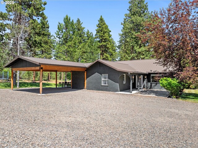 14955 Profitt Loop, Baker City, OR 97814 - view of front of home featuring a metal roof, gravel driveway, and stucco siding