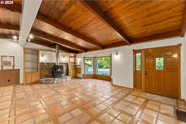 unfurnished living room featuring visible vents, a wood stove, wooden ceiling, baseboards, and vaulted ceiling with beams