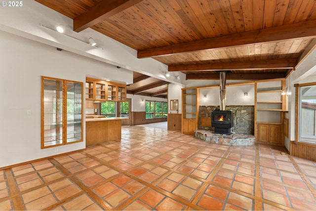 unfurnished living room featuring lofted ceiling with beams, wood ceiling, and a wood stove