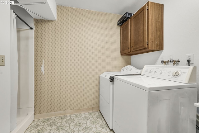 laundry room with separate washer and dryer and cabinets