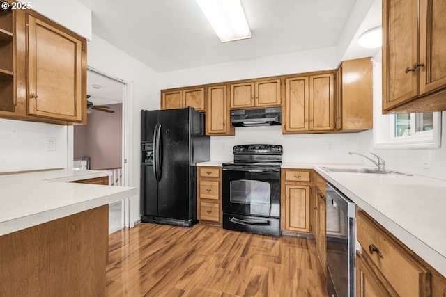 kitchen featuring black appliances, light hardwood / wood-style floors, and sink