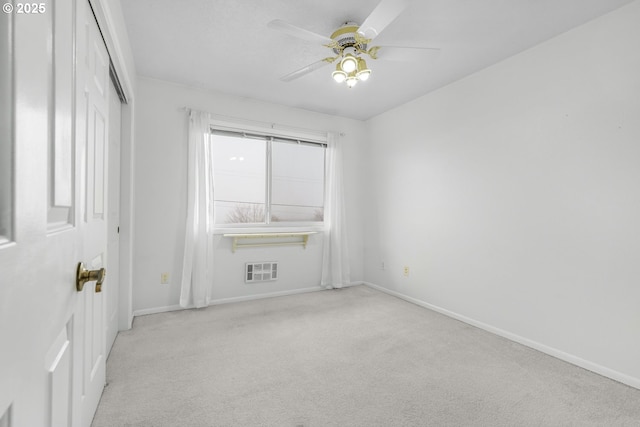 empty room with ceiling fan and light carpet