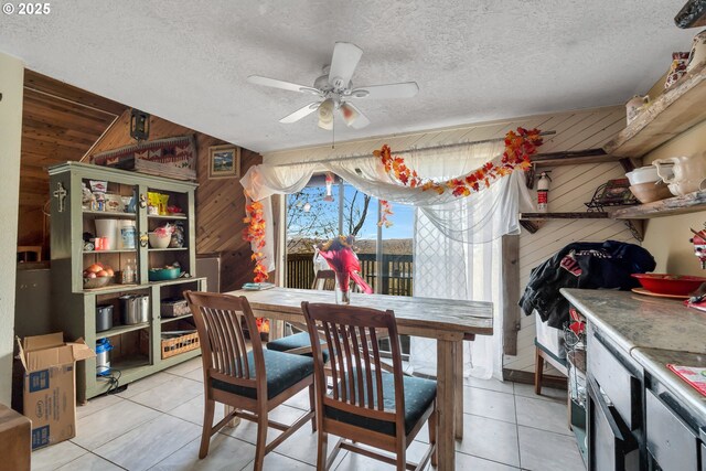 6596 River Rd, Salem, OR 97306 - dining space with wooden walls, a ceiling fan, a textured ceiling, and light tile patterned floors