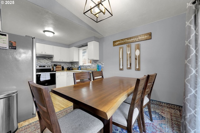 dining room featuring an inviting chandelier and vaulted ceiling