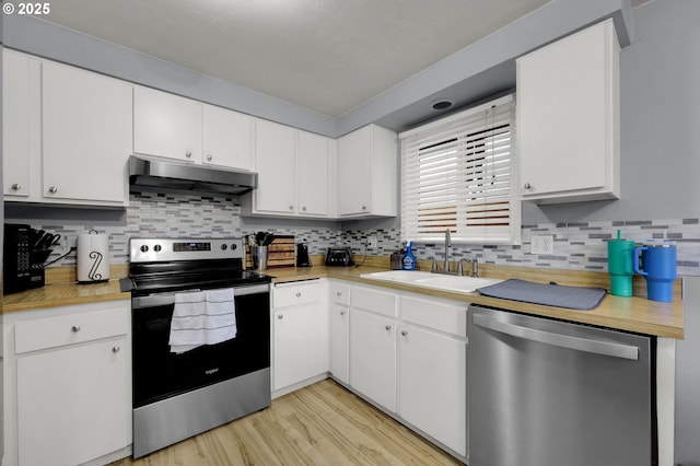 kitchen featuring white cabinetry, sink, stainless steel appliances, and light wood-type flooring