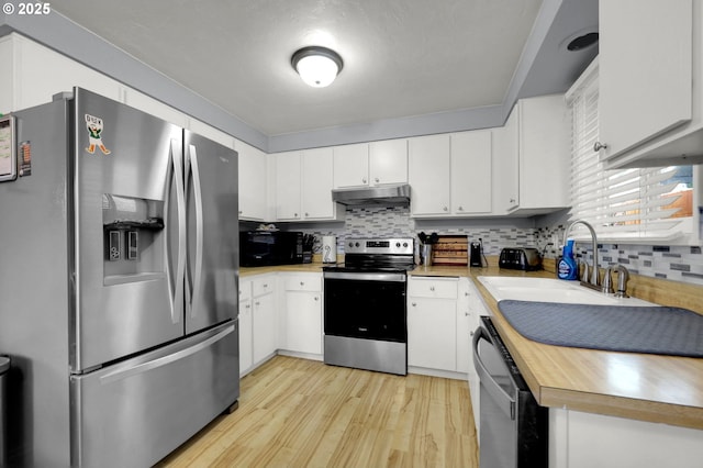 kitchen featuring backsplash, sink, appliances with stainless steel finishes, light hardwood / wood-style floors, and white cabinetry